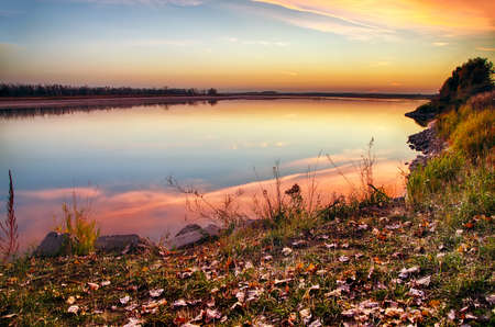 Golden orange sunset over the calm waters of the river.