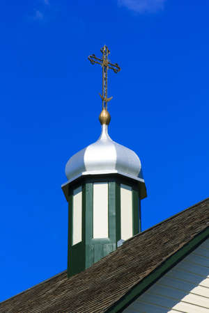 Details of a church steeple with a metal cross on top of itの写真素材