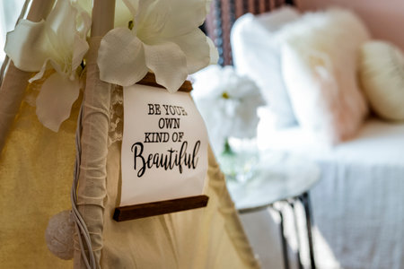 A white tarp with a sign that says Be your own kind of beautiful.. The sign is hanging from the top...