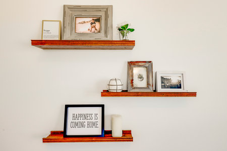 Three shelves with pictures and a sign that says "Rejoice is the beginning of a new life"の写真素材
