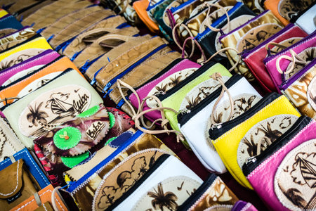 A collection of purses with different colors and designs. The purses are displayed in a store or market settingの写真素材