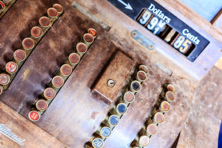 A National Cash Register with a wooden counter and a black and white screen. The screen has a dollar sign and a 995 cents signの写真素材