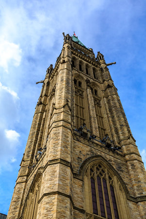 A tall, brown building with a green dome on top. The building is surrounded by a blue skyの写真素材