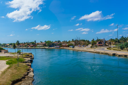 A small town with a river running through it. The water is calm and the sky is blueの写真素材