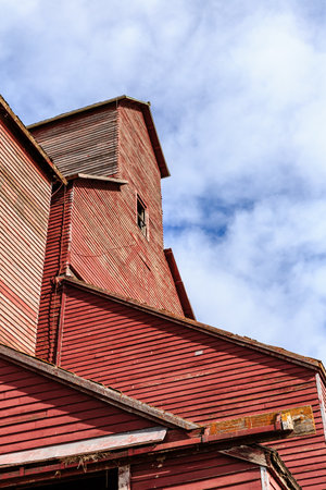 A red building with a red roof and a window. The building is old and has a rustic appearanceの写真素材