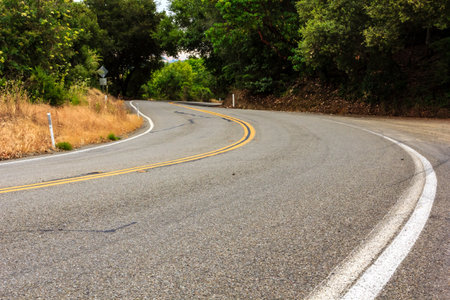 A road with a yellow line down the middle. The road is empty and straightの写真素材