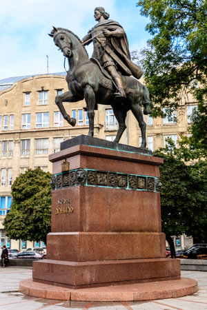 A statue of a man on horse with the name of a king on it. The statue is surrounded by a red stone baseの写真素材