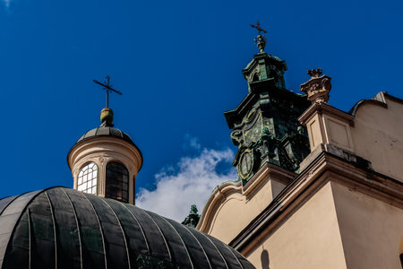 A church with a dome and a cross on top. The dome is green and the cross is whiteの写真素材