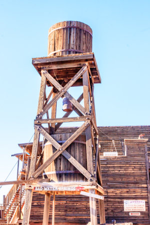A tall wooden structure with a sign that says Old Water Company. The structure is surrounded by a wooden fenceの写真素材