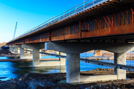 A bridge is being built over a body of water. The bridge is made of concrete and steelの写真素材