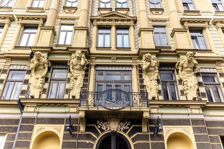 The building has statues of men on the front. The building is old and has a lot of windowsの写真素材