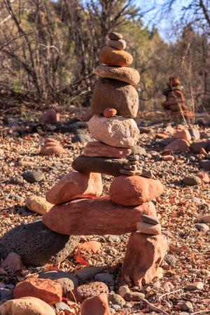 A stack of rocks is arranged in a pyramid shape. The rocks are of different sizes and colors, creating a visually interesting and unique structureの写真素材