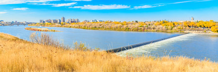A beautiful view of a river with a bridge in the background. The sky is clear and the sun is shining brightlyの写真素材