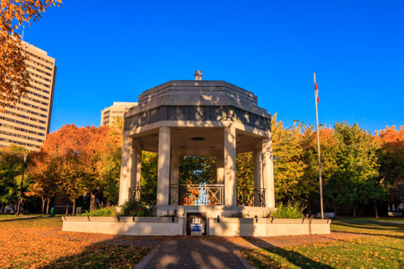 A large, ornate building with a fountain in the middle. The fountain is surrounded by trees and leaves. The scene is peaceful and serene, with the fountainの写真素材