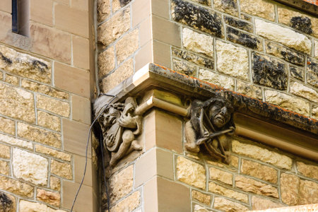 The two statues on the wall are of gnomes, one of which is holding a sword. The gnomes are carved into the stone wall, and they appear to be looking at the viewer. Scene is mysterious and intriguingの写真素材