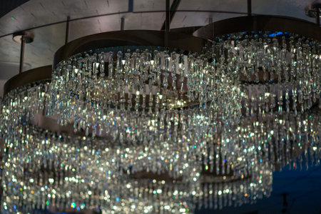 A chandelier with many crystal pieces hanging from it. The chandelier is very large and has a lot of light reflecting off of itの写真素材