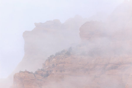 A mountain range covered in fog. The fog is so thick that it obscures the entire mountain rangeの写真素材