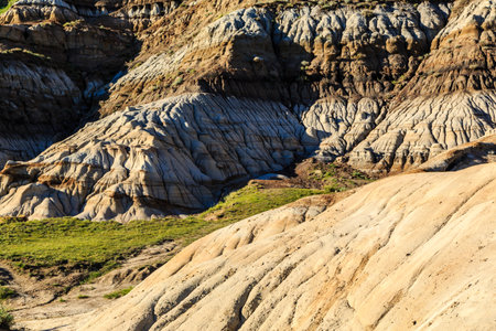 A rocky hillside with a grassy area in the foreground. The hillside is covered in rocks and the grass is greenの写真素材