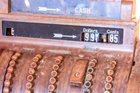 An antique cash register with a price of 9.85 cents. The register is old and has a worn appearance, with a black and white label that reads "Cash." The register has a few buttons and a keypadの写真素材