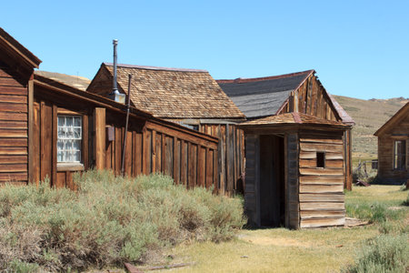 A small building with a window and a door. The building is surrounded by a fence and is located in a...