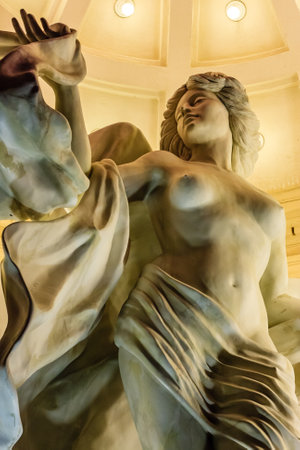 A classical marble sculpture depicting a mythological figure in flowing drapery, showcasing Renaissance artistry and craftsmanshipの写真素材