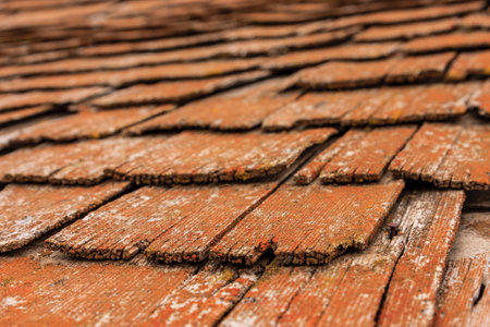 The roof is made of wood and has a rustic appearance. The wood is weathered and has a worn look to itの写真素材