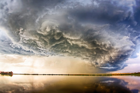 A stormy sky with a large cloud in the middle. The sky is dark and the clouds are thick