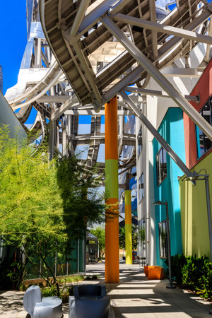 A walkway with a green and yellow pole in the middle. The pole is surrounded by trees and plantsの写真素材