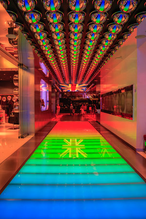 A colorful walkway with a British flag on it. The walkway is lit up with neon lights and is surrounded by a glass wallの写真素材