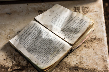 A book is open to a page with a few words on it. The book is old and has a worn appearanceの写真素材