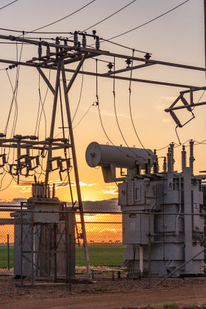Power poles and transmission lines at sunset.
