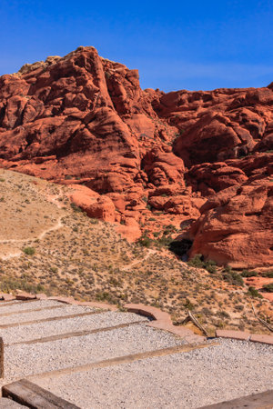 A mountain range with a red rock formation. The mountain is covered in red rocks and the sky is blueの写真素材