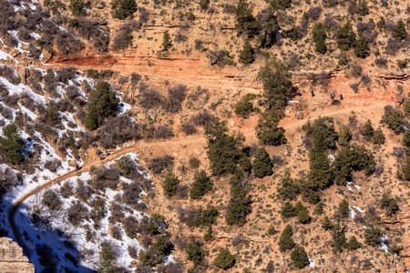 A rocky, barren landscape with a path through it. The path is surrounded by trees and rocks, and...