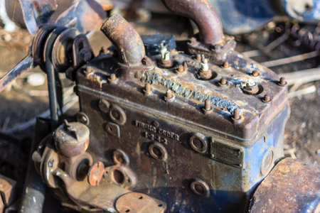 An old engine with a blue cover and a black and white label. The engine is rusted and has many holes