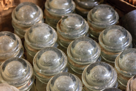 A bunch of old glass jars with a brownish tint. The jars are stacked on top of each otherの写真素材