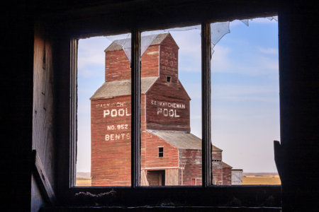 A window in a building with a sign on the side. The building is in the distanceの写真素材