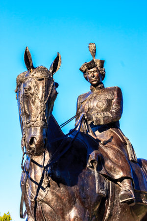 A statue of a woman riding a horse. The statue is made of bronze and is located in a parkの写真素材