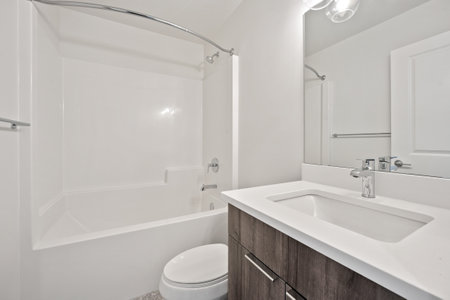 A bathroom with a white toilet and sink. The bathroom is clean and well-maintained