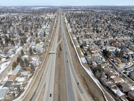 City street with a highway running through it. The street is empty and the houses are small