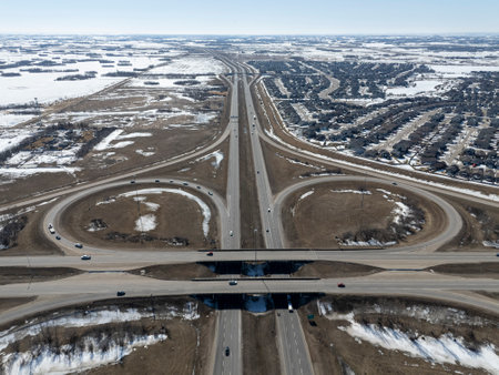 Highway with a lot of cars on it. The highway is surrounded by snow and has a lot of curves