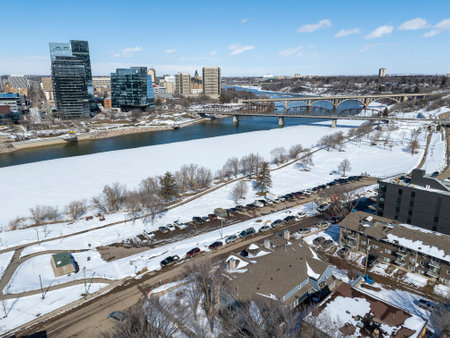 Snowy cityscape with a river running through it. The buildings are tall and the sky is clearの写真素材