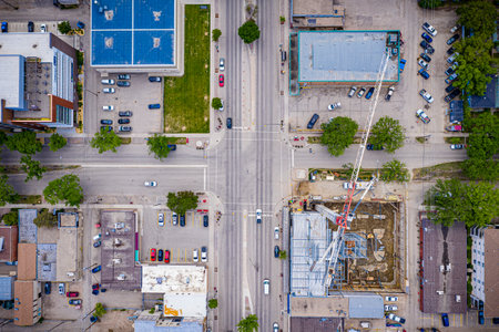 City street view with a crane in the middle of the intersection. The crane is being used to build a...