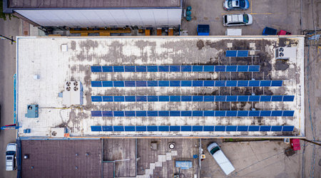 Blue sky with a white roof and a row of solar panels. Concept of sustainability and environmental...