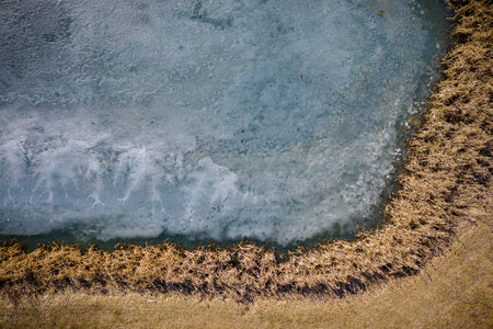 Body of water with a brownish-yellow line running along the edge. The water appears to be murky and...