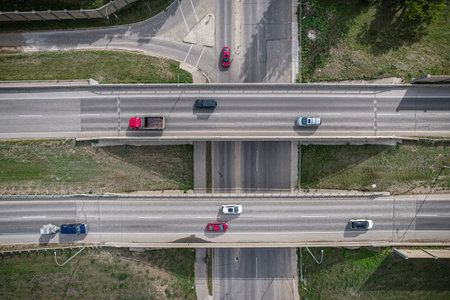Busy highway with cars and a truck crossing over a bridge. The cars are moving at different speeds...
