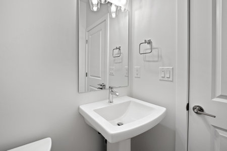 Bathroom with a white sink and toilet. The bathroom is clean and well-maintainedの写真素材
