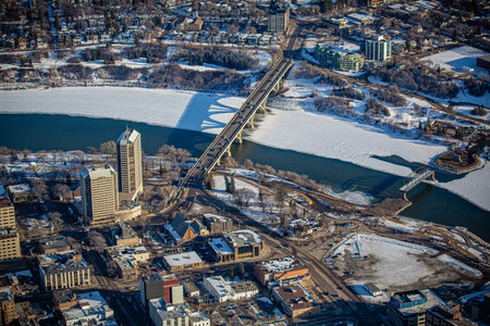 City view with a bridge over a river. The city is covered in snow and the buildings are tallの写真素材