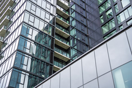 Tall building with a lot of windows and a balcony. The building is very tall and has a lot of glass...