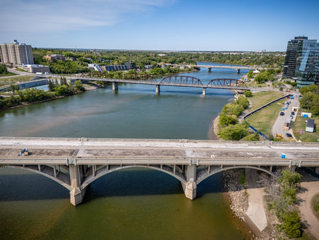 Bridge spans a river with a city in the background. The bridge is a large structure that connects two sides of the riverの写真素材