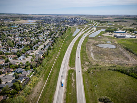 Highway with a truck driving down it. The road is empty and the sky is clear. The truck is driving...